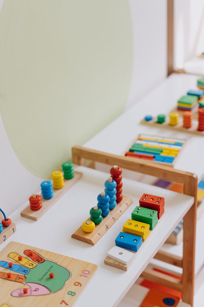 Bright and colorful educational wooden toys displayed on a table in a classroom.